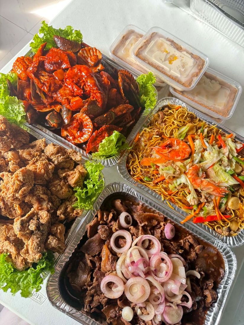 Chef R's Kitchen catering spread with seafood, noodles, chicken and beef trays